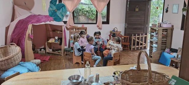 Crianças reunidas em roda na sala acolhedora com cabana de tecidos